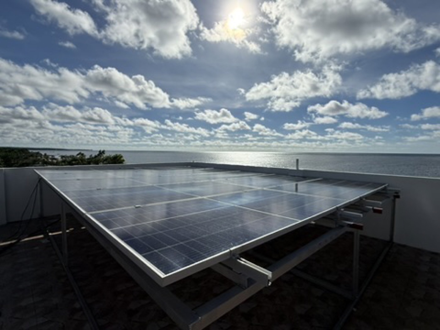 Coastal rooftop solar array under heavy cloud during the rainy season