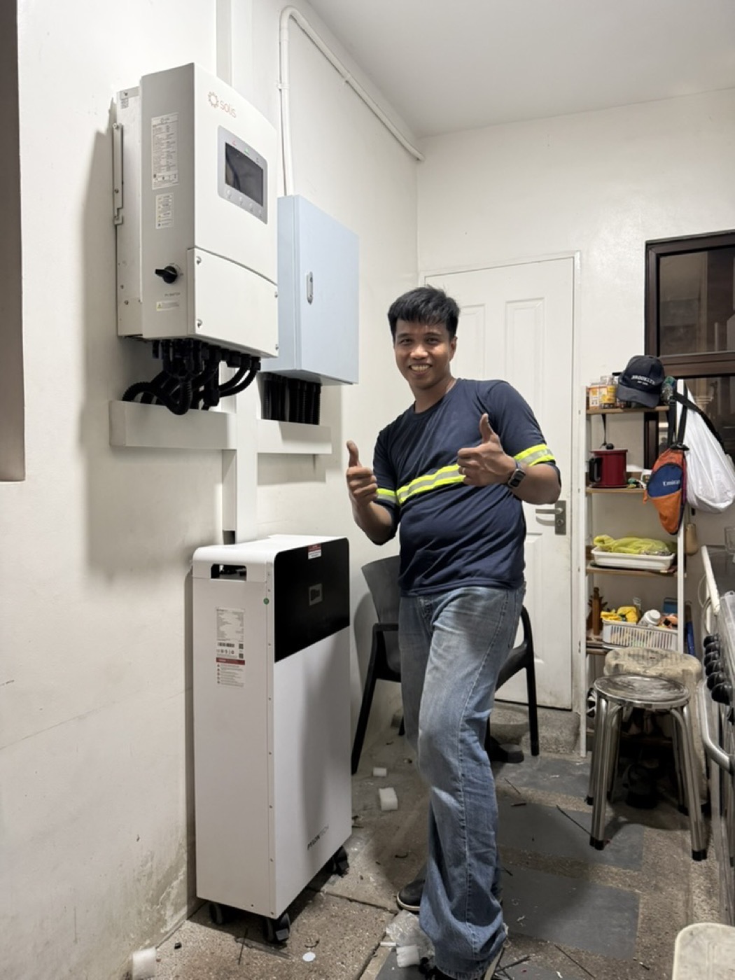 Bolinao Solar technician giving a thumbs up beside a newly installed home battery