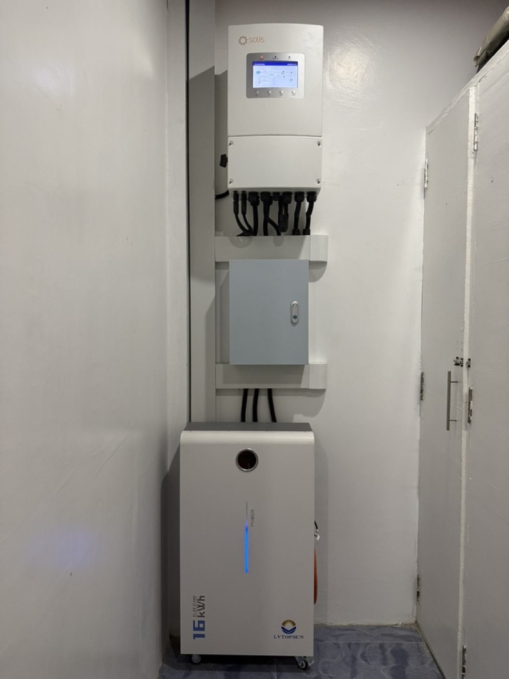 Solar inverter and conduit mounted on a wall, showing the metering and connection point