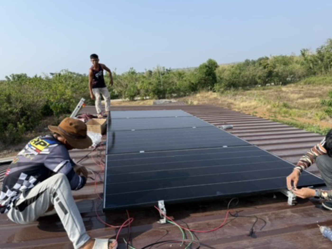 Solar panels being installed on open farmland, the kind of array used for water pumping